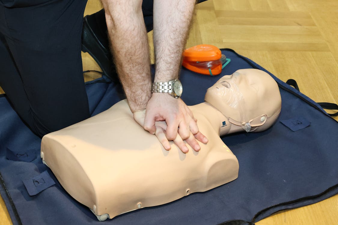 Person performing chest compressions on CPR training mannequin