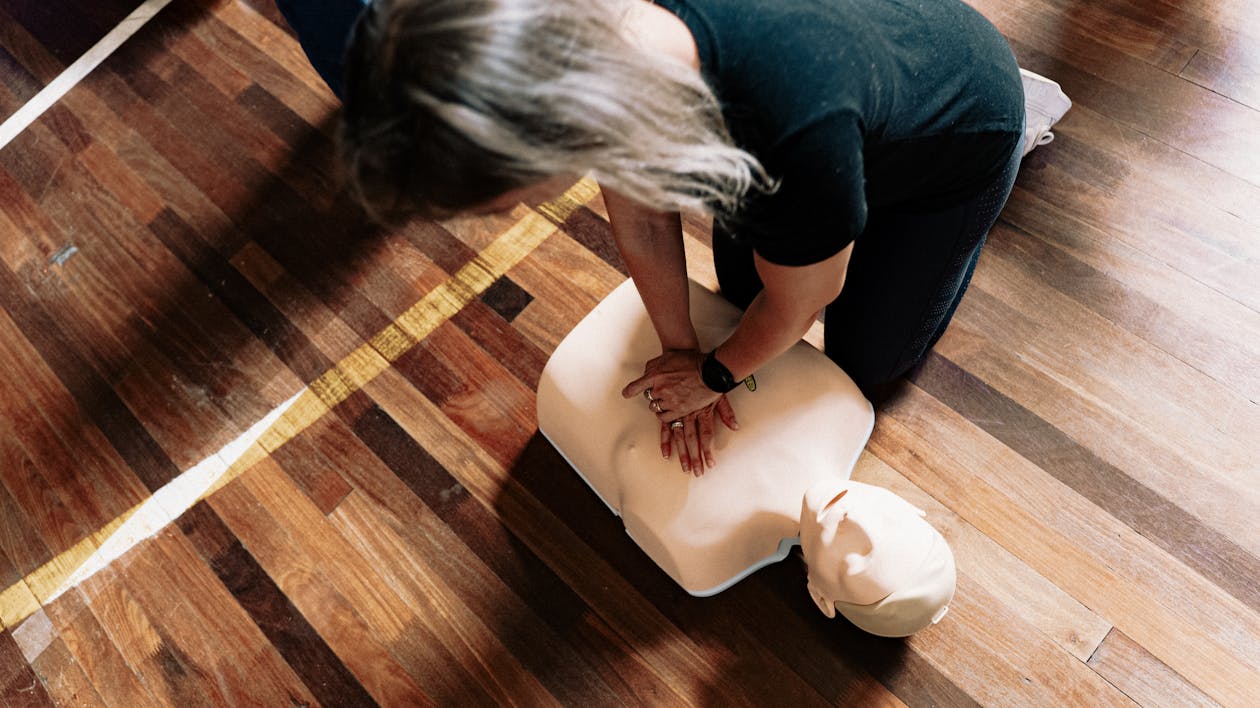CPR instructor demonstrating proper chest compression technique on mannequin